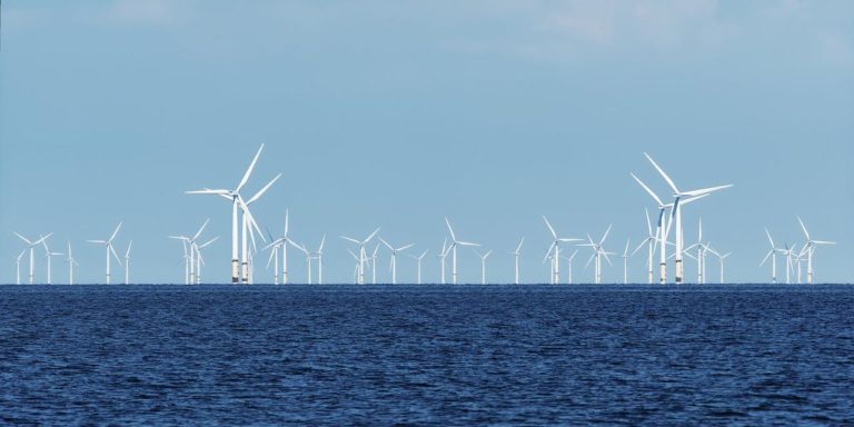 Unos treinta generadores eólicos instalados en el mar que se alzan en el horizonte.